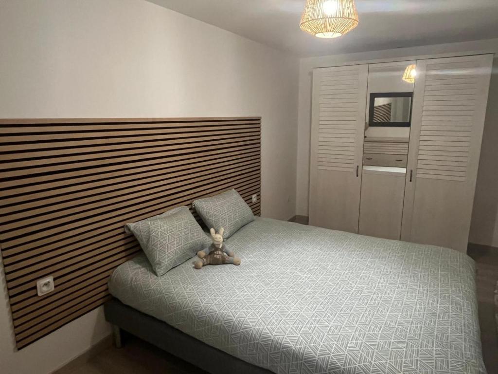 - un ours en peluche assis sur un lit dans une chambre dans l'établissement T2 Troyes, à Troyes