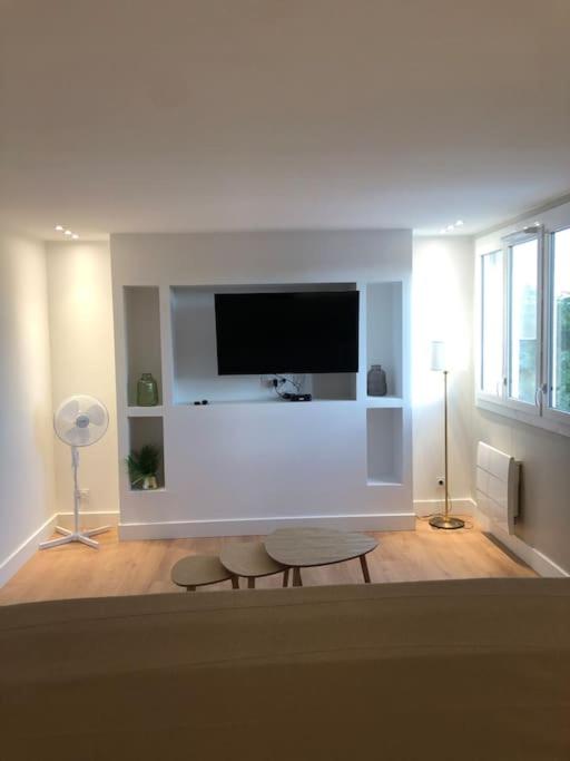 un salon avec une télévision à écran plat sur un mur dans l'établissement Le Morison Bonnefoy - T2 - Parking - Proche Gare, à Toulouse