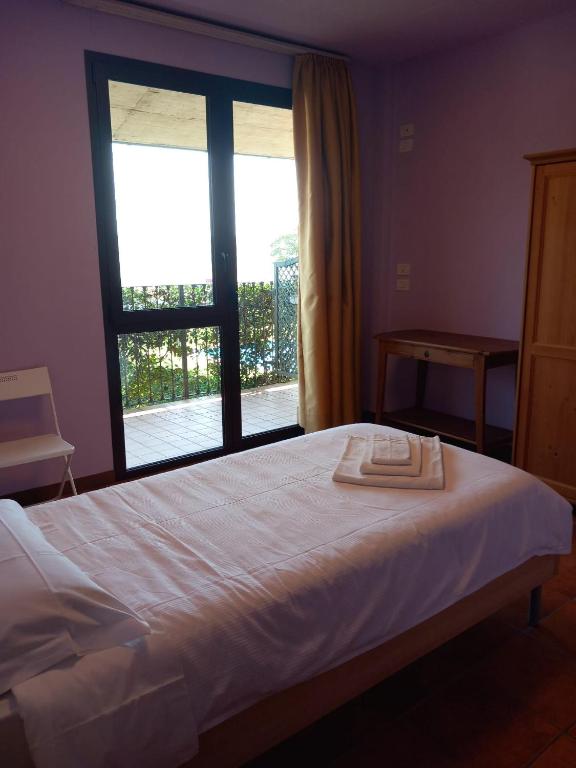 a bedroom with a bed with a large window at Agriturismo La Bella Manza in Lurate Caccivio