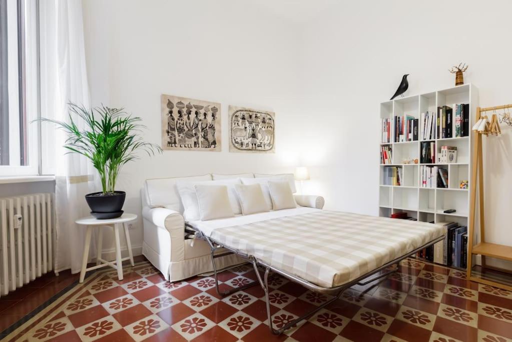 Pokój z łóżkiem i półką na książki w obiekcie New Design Apartment w Mediolanie