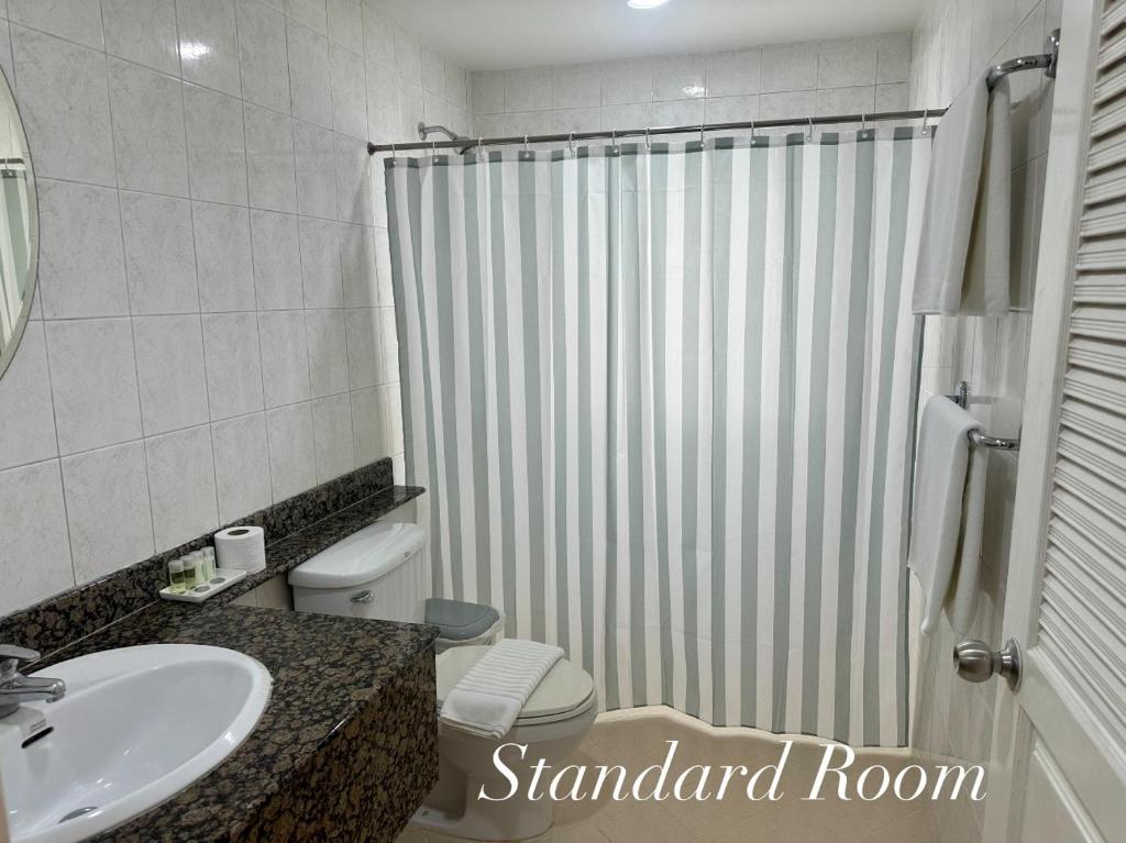 a bathroom with a shower and a toilet and a sink at Surin Bay Inn in Surin Beach