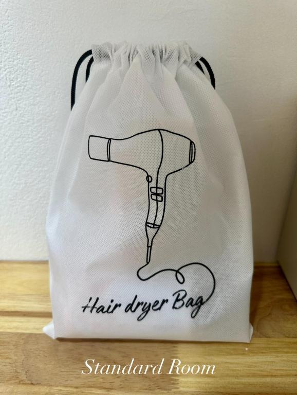 a white shopping bag with a hair dryer on it at Surin Bay Inn in Surin Beach