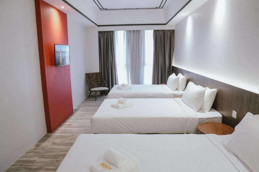 Postel nebo postele na pokoji v ubytování Roxy Hotel Siniawan