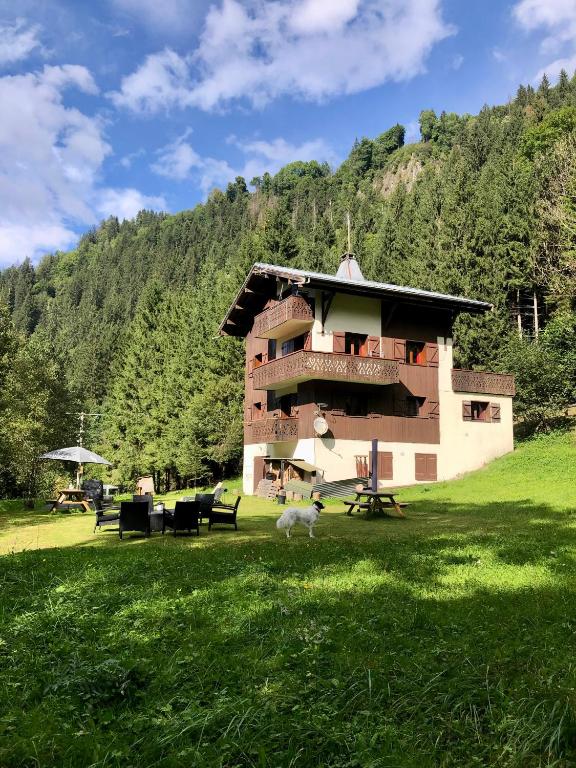 un bâtiment au milieu d'une pelouse dans l'établissement Chalet Rivière du Bon Nant Location de 6 à 14 personnes en Haute Savoie, à Saint-Gervais-les-Bains