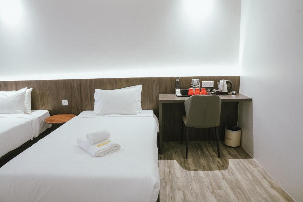 Postel nebo postele na pokoji v ubytování Roxy Hotel Siniawan