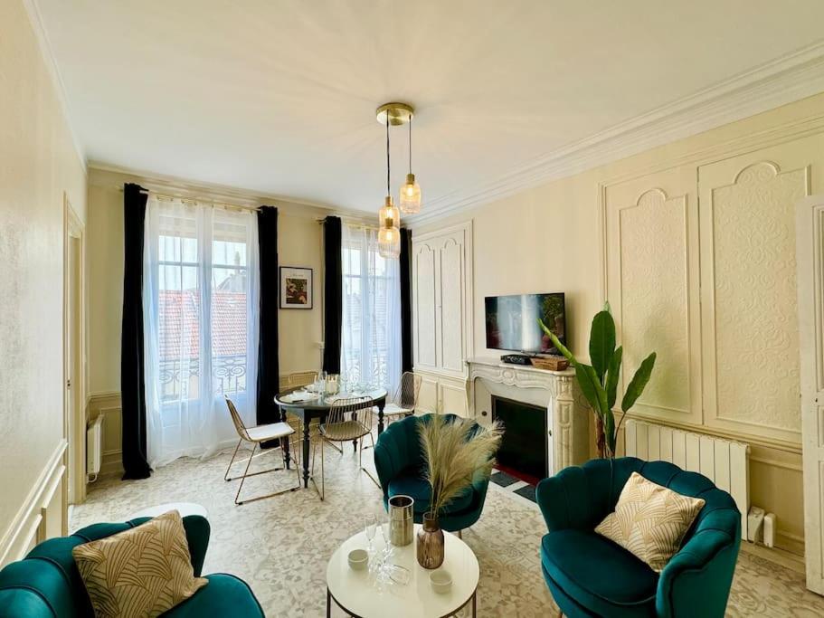 un salon avec des chaises bleues et une table dans l'établissement Les Palmettes Hypercentre Reims, à Reims