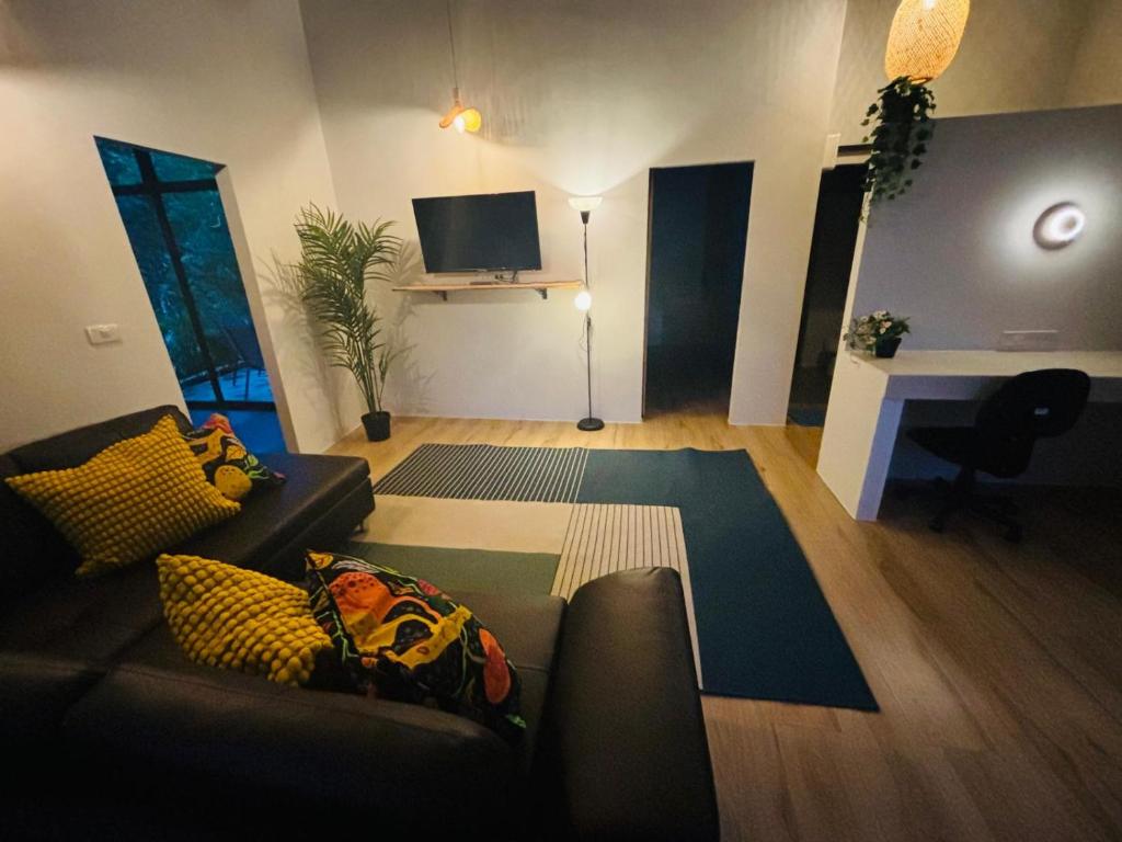 Una sala de estar con un sofá y un televisor. en JK House, en Ko Pha Ngan