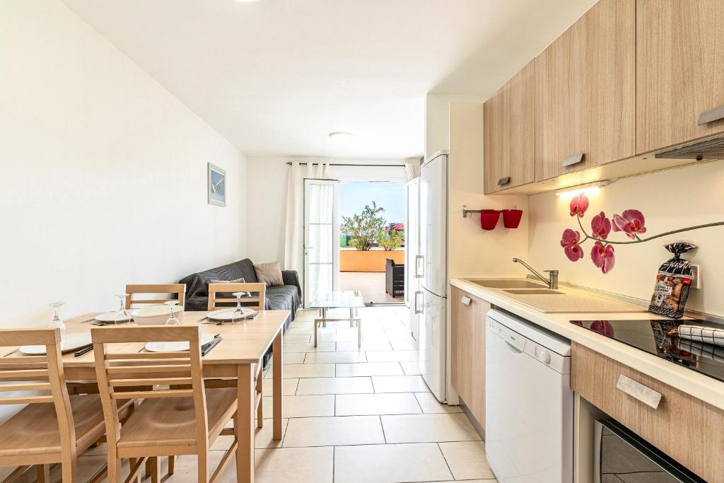 une cuisine et un salon avec une table et des chaises dans l'établissement La Marina - Appt climatisé pour 4, à Sari-Solenzara