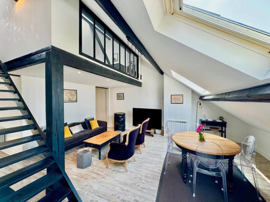 - un salon avec un escalier, une table et un canapé dans l'établissement Botti Sacre - Reims pétillant, à Reims
