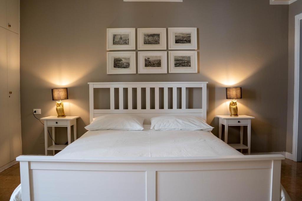 a bedroom with a white bed with two side tables at Canard Suite in Bologna
