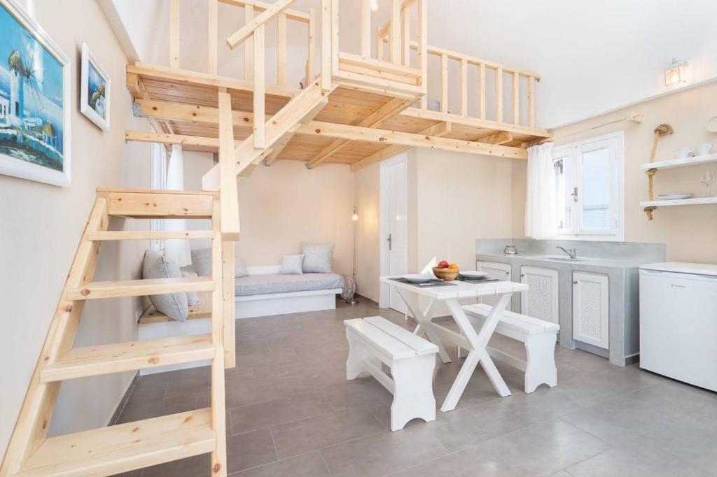 a room with a loft bed and a table and a kitchen at Santa Irini 2 in Vourvoúlos
