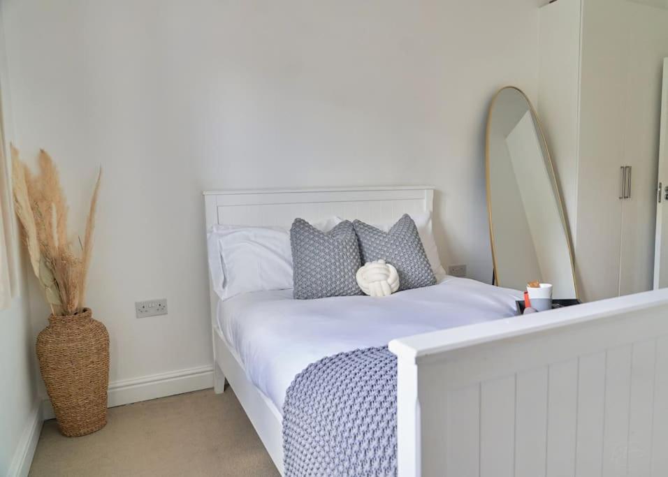 a bedroom with a white bed with a teddy bear on it at Spacious Two Bedroom Hideaway in Wokingham with En Suite, Free Wi Fi and Parking, Sleeps Four in Wokingham