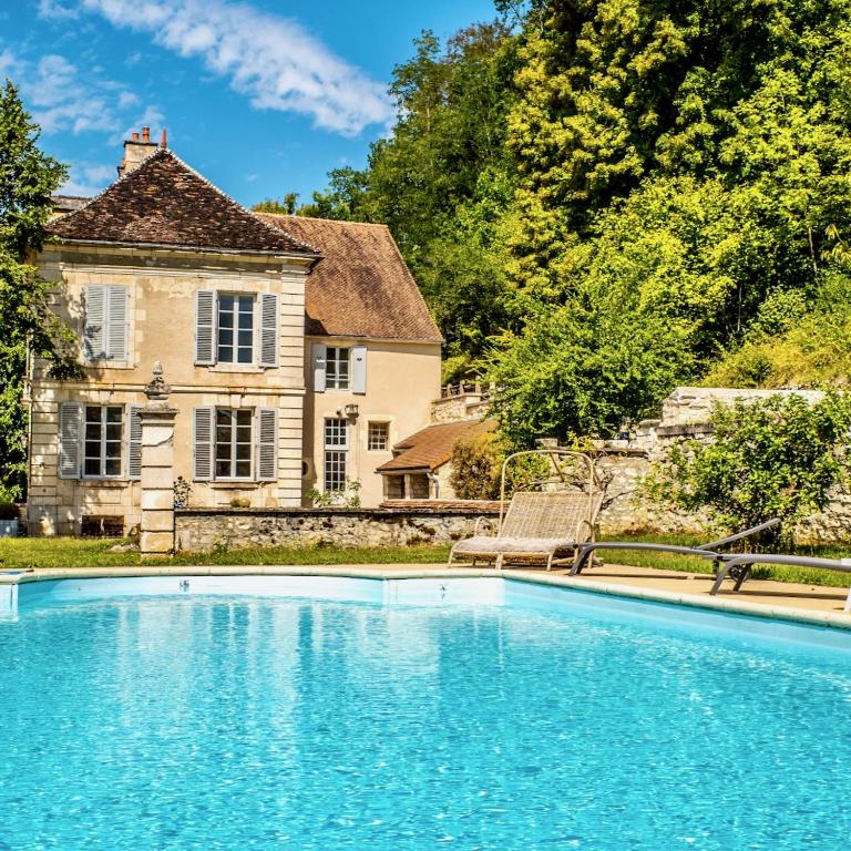 un domaine avec une piscine devant une maison dans l'établissement Gîte Château du Colombier - Piscine chauffée, à Mailly-le-Château