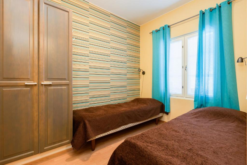 a bedroom with two beds and blue curtains at Levillenet Glacier Alpine Chalets at Levi Centre in Levi