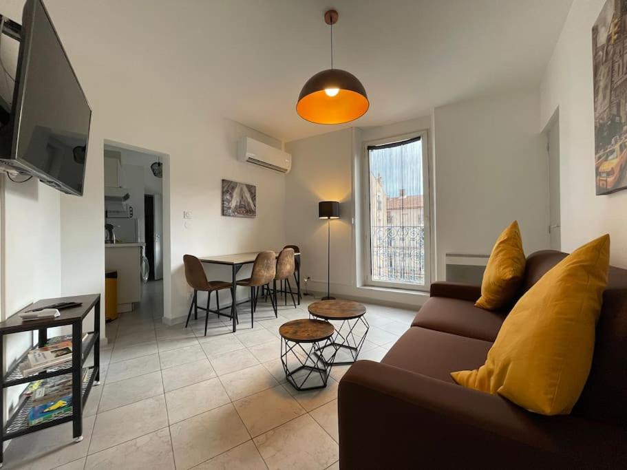 a living room with a couch and a table at Bel appartement Béziers - Clim - 1 Chambre - Gare - Centre in Béziers