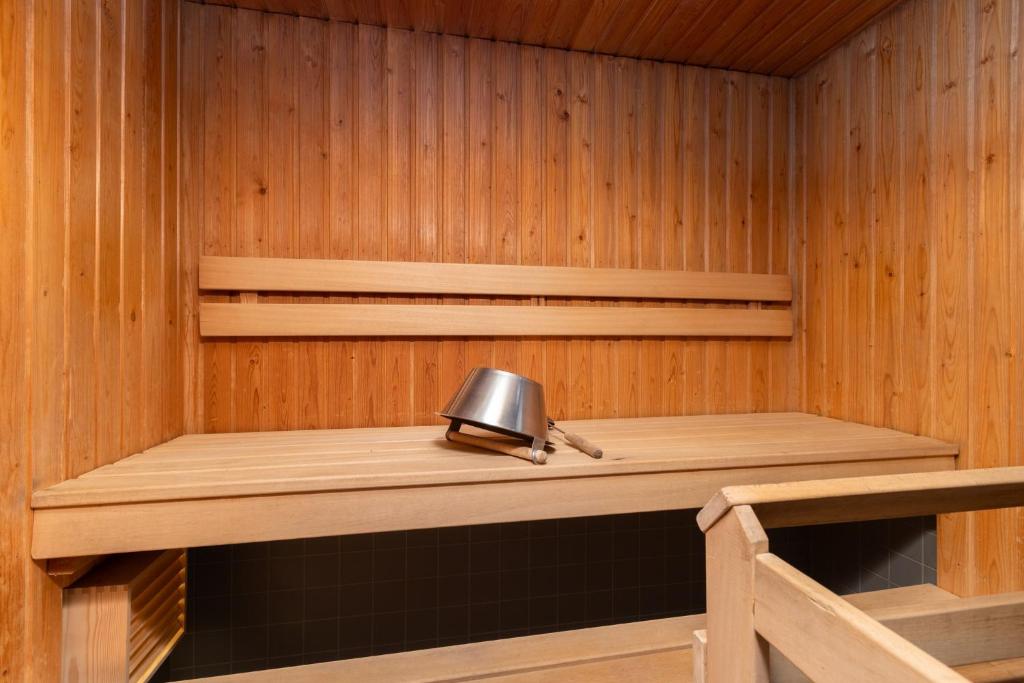 a sauna with a wooden shelf and a bell at Levillenet Glacier Alpine Chalets at Levi Centre in Levi