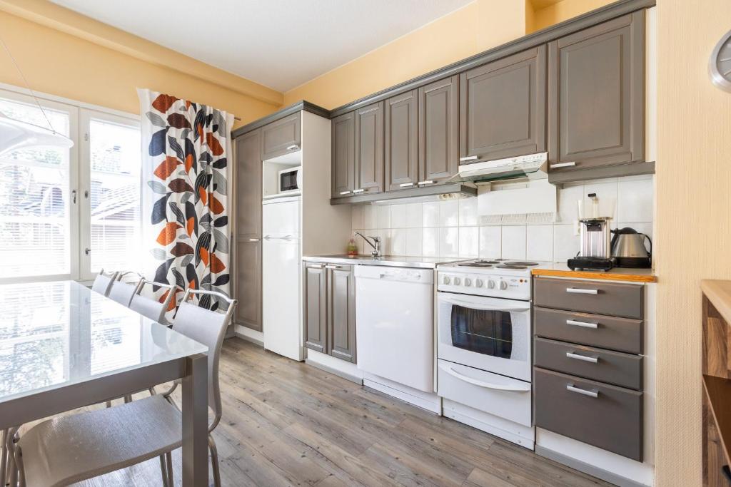 a kitchen with gray cabinets and white appliances at Levillenet Glacier Alpine Chalets at Levi Centre in Levi