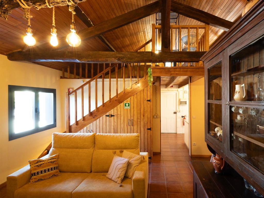 ein Wohnzimmer mit einem Sofa und einer Holzdecke in der Unterkunft Quintinha do Varoso - Little Red Cottage House in São Pedro do Sul