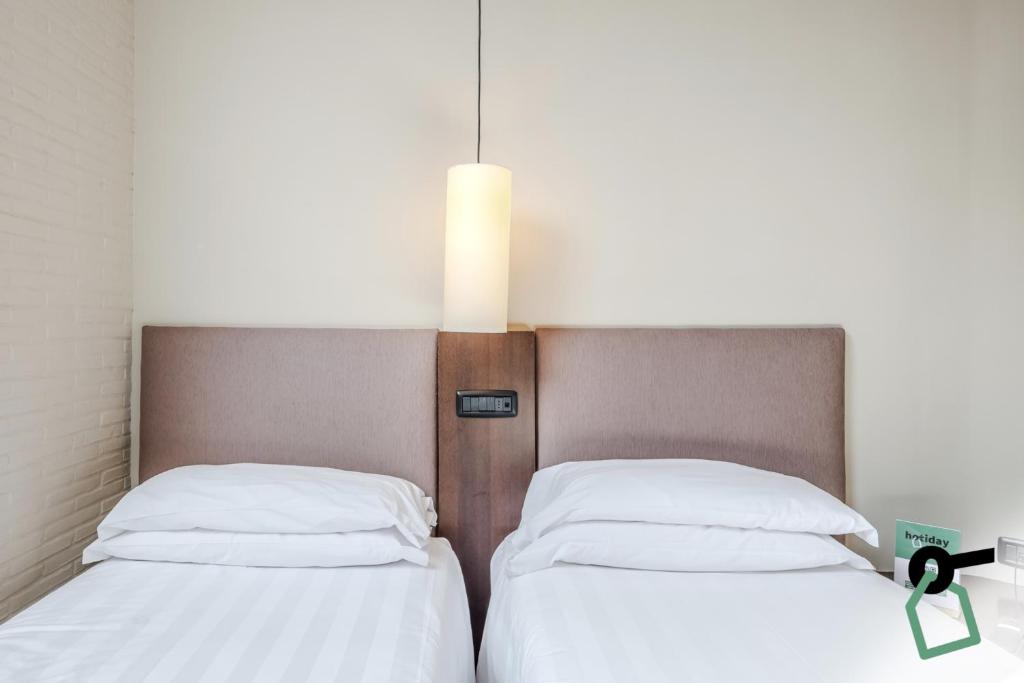 Postel nebo postele na pokoji v ubytování HOTIDAY Room Collection - Roma Cornelia