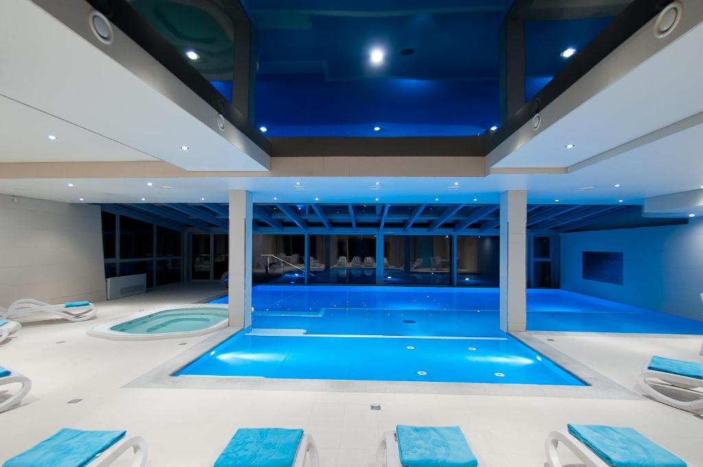 a swimming pool in a house with a blue ceiling at Hotel New Wave in Wisła