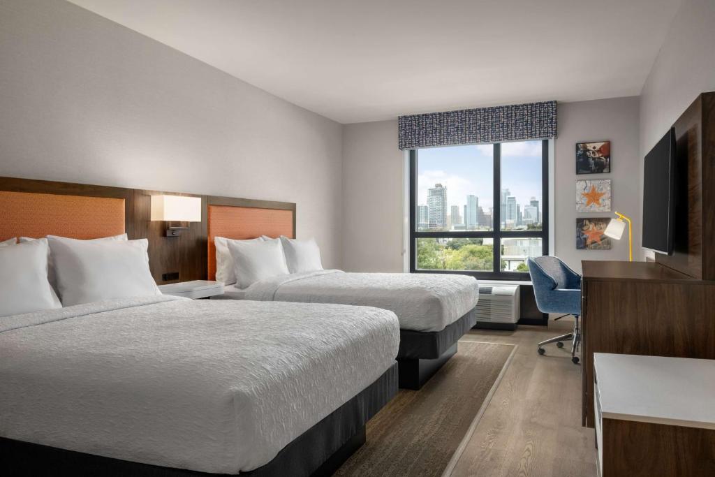a hotel room with two beds and a television at Hampton by Hilton East Austin - near UT and Capitol in Austin