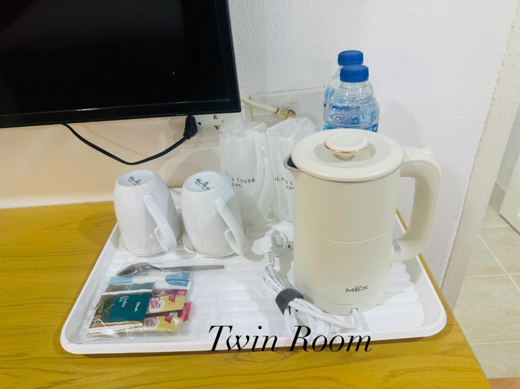 a tea kettle on a tray on a table at Surin Bay Inn in Surin Beach