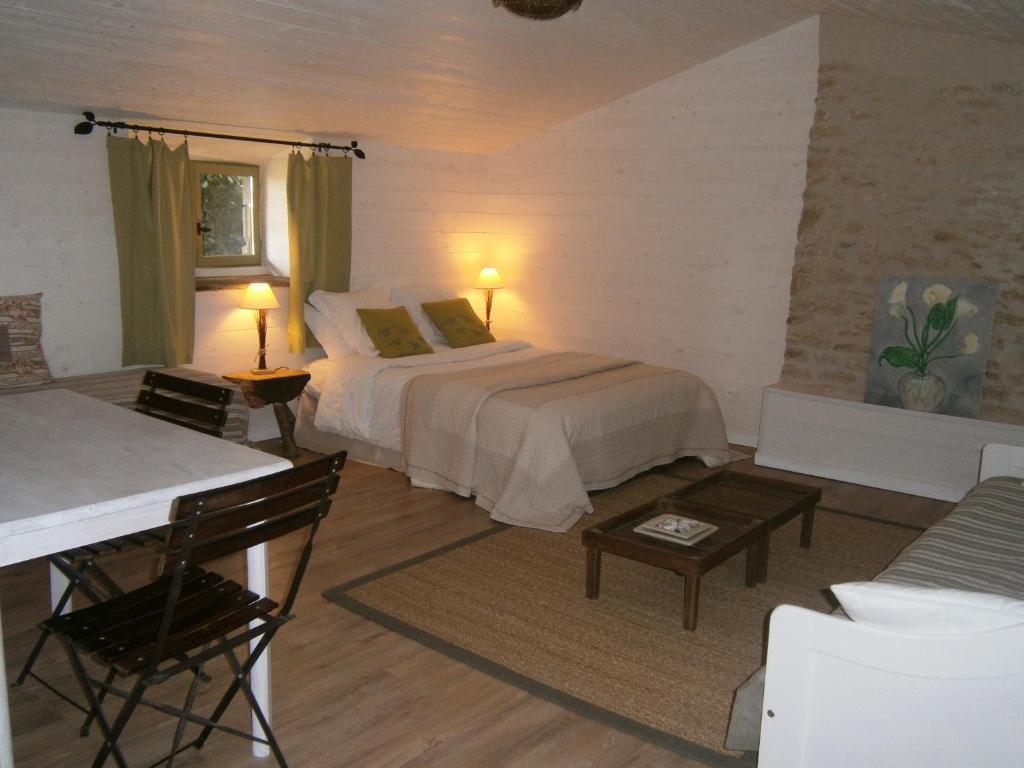a bedroom with a bed and a table and a couch at A la campagne in Champagné-Saint-Hilaire