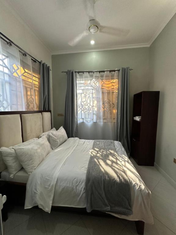 a bedroom with a white bed and a window at Amazing home stays 9 in Dar es Salaam