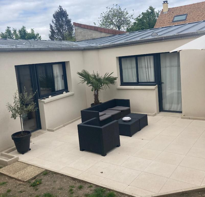 d'une terrasse avec 2 chaises et une plante. dans l'établissement Studio style loft, à Mantes-la-Jolie