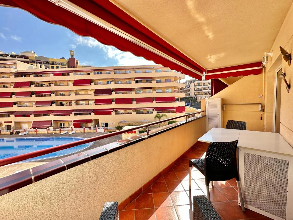 Un balcón con vista a un edificio y una piscina. en Daniela Garden, en Puerto de Santiago