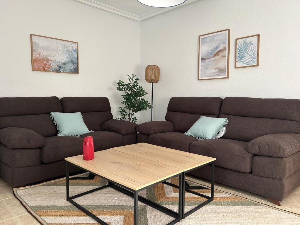a living room with a couch and a coffee table at Casa Rural Fuente Vieja in Malpartida de Plasencia
