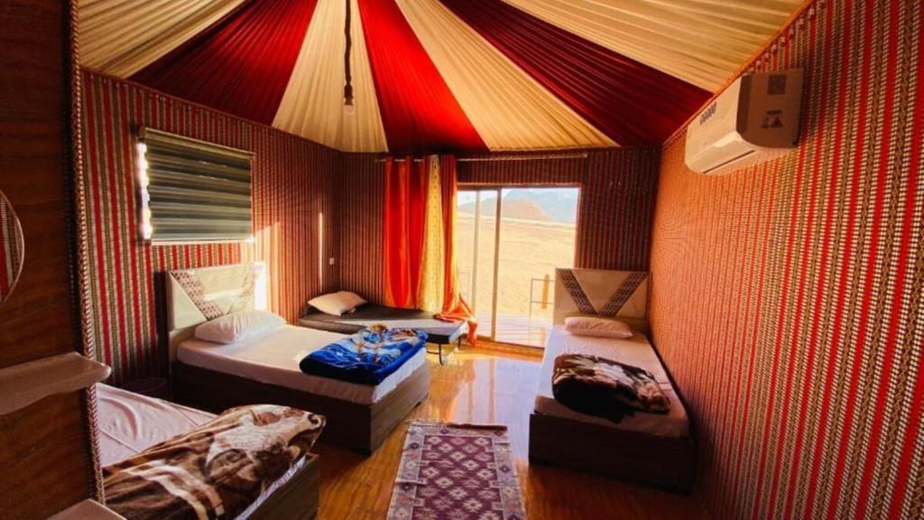 Una habitación con una tienda de campaña con dos camas y una ventana. en Wadi Rum Camp tr, en Wadi Rum