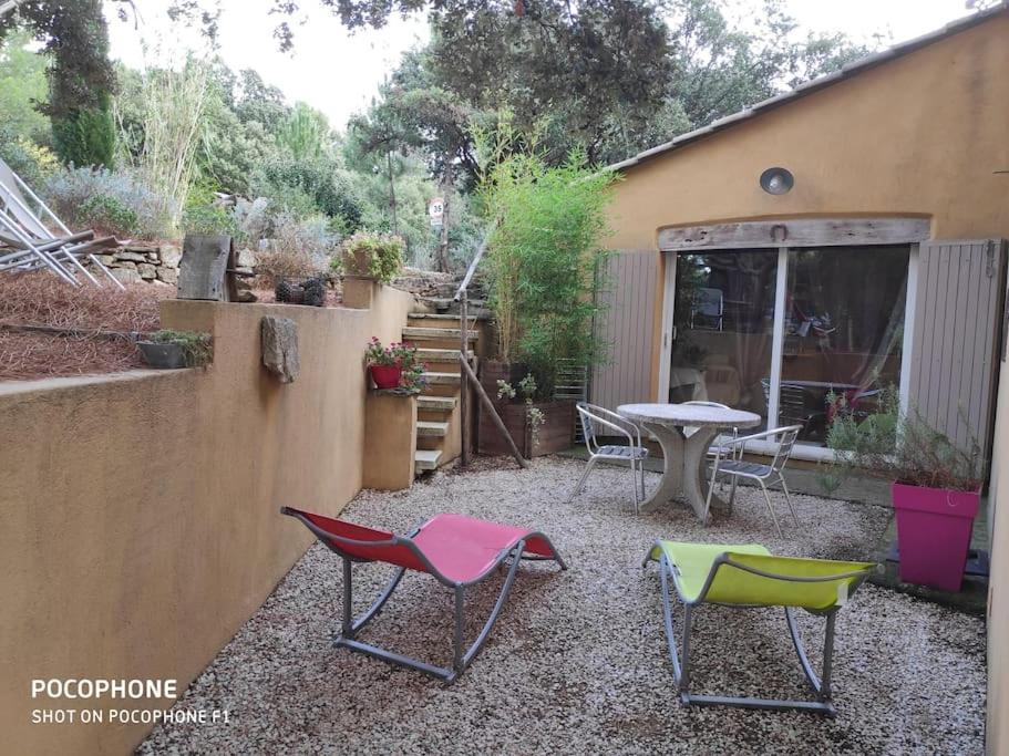 un patio avec deux chaises et une table dans une cour dans l'établissement La POULIDO au pied du Mont Ventoux PROVENCE, à Bédoin