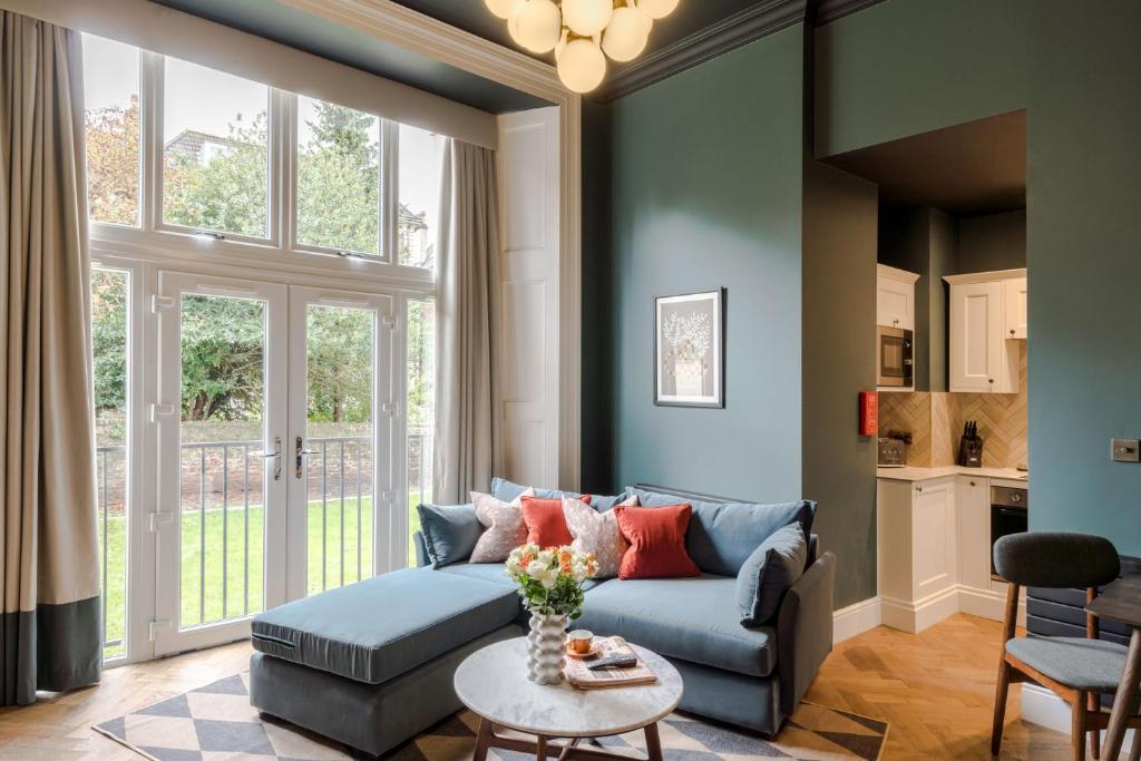 a living room with a blue couch and a table at Tyndall's Park - Your Apartment in Bristol