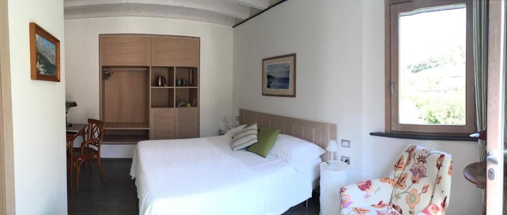 a bedroom with a white bed and a kitchen at La Casa di Andrea Relais in Monterosso al Mare