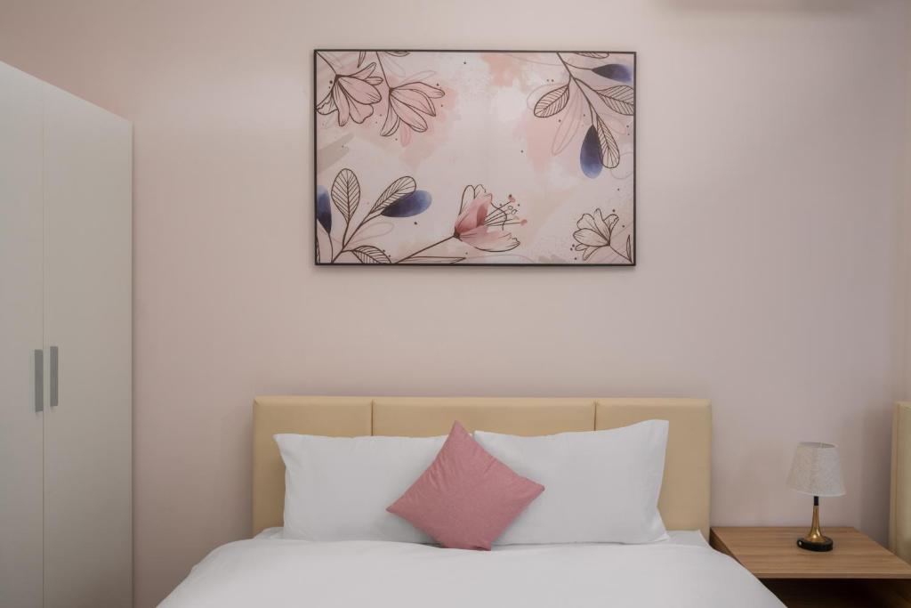 a bedroom with a bed with a picture above it at Phê Hotel in Da Nang