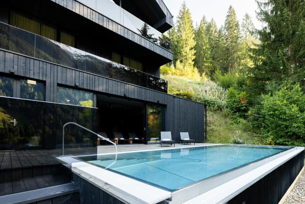 a swimming pool in front of a building at Paznauner Villen - Villa I in Kappl