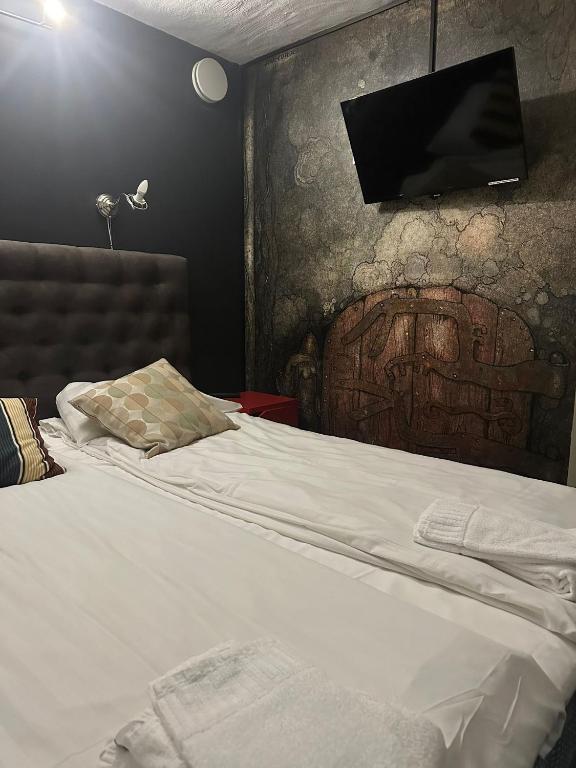 a bedroom with a bed with a tv on the wall at Hotell Skeppsbron in Stockholm