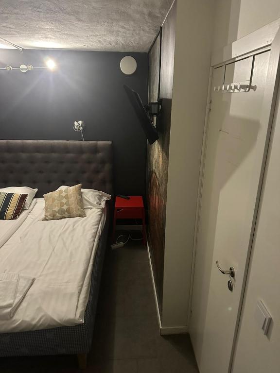 a small bedroom with a bed and a small door at Hotell Skeppsbron in Stockholm