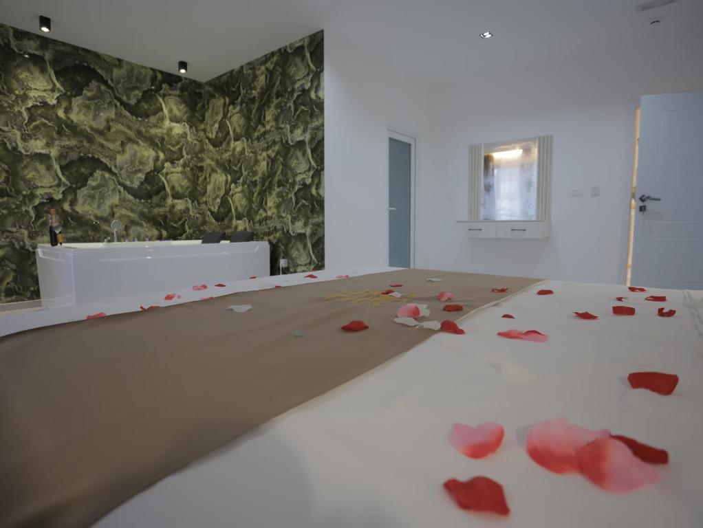 a bedroom with red rose petals on a bed at Shatri Hotel in Vranisht
