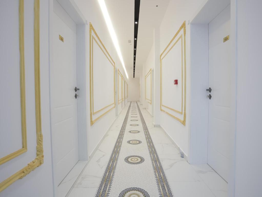 a hallway with white walls and a tile floor with a long corridor at Shatri Hotel in Vranisht