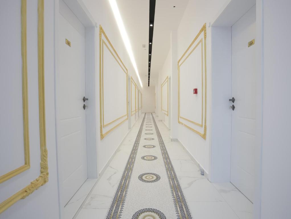 a hallway with white walls and a tile floor with a long corridor at Shatri Hotel in Vranisht