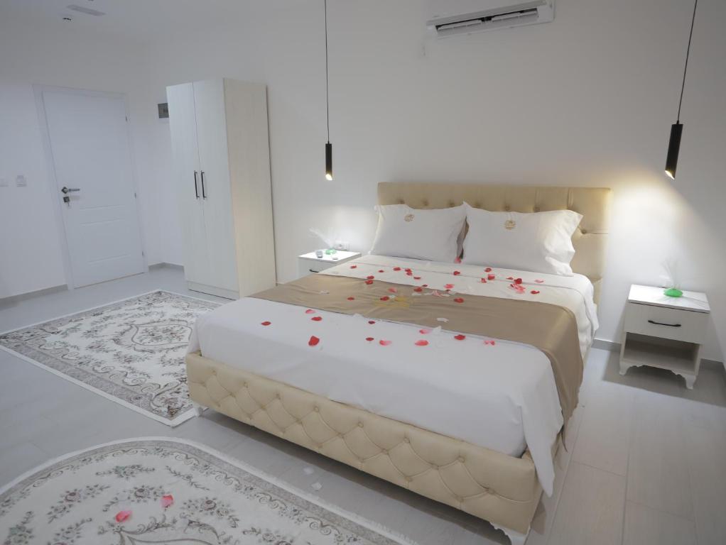 a bedroom with a large bed with red flowers on it at Shatri Hotel in Vranisht