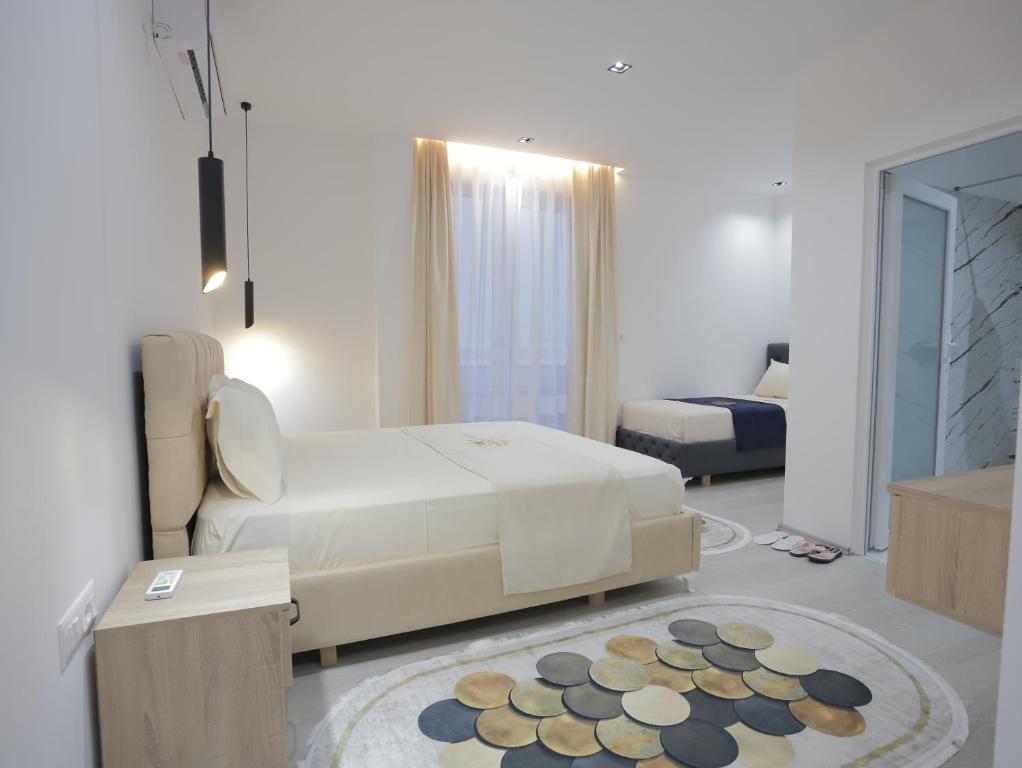 a white room with a bed and a rug at Shatri Hotel in Vranisht