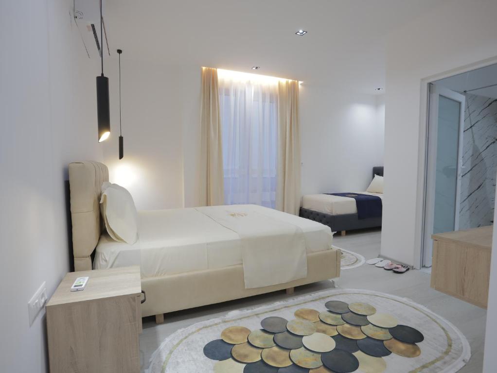 a white room with a bed and a rug at Shatri Hotel in Vranisht