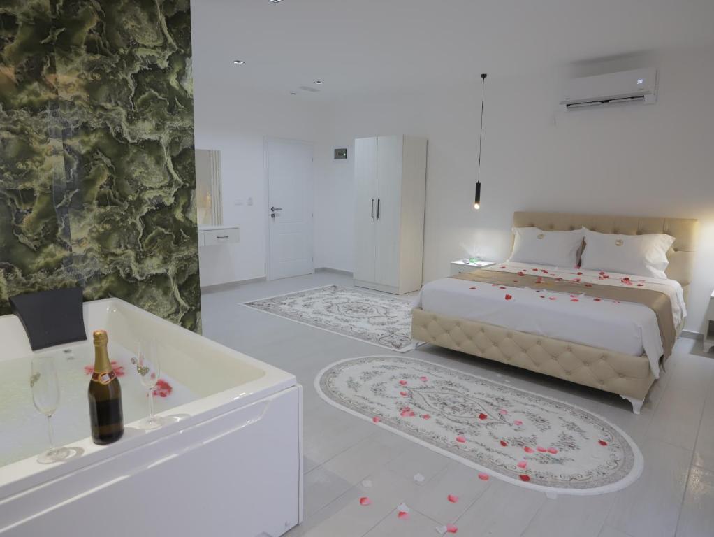a white bedroom with a bed and a bath tub at Shatri Hotel in Vranisht