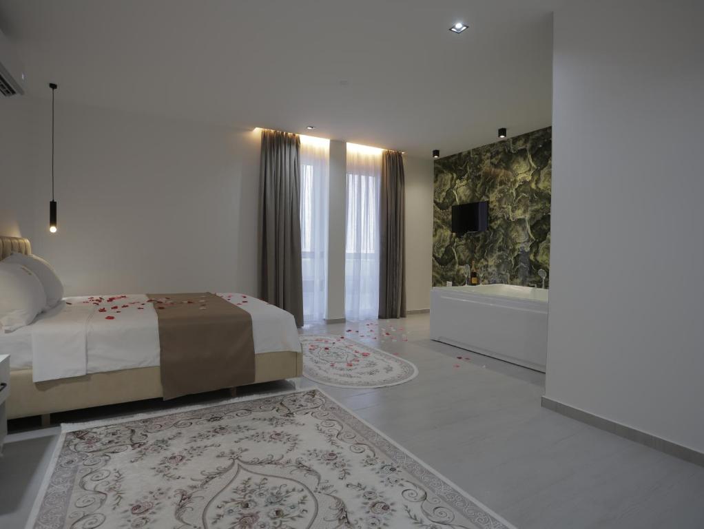 a bedroom with a bed and a bath tub and a tub at Shatri Hotel in Vranisht