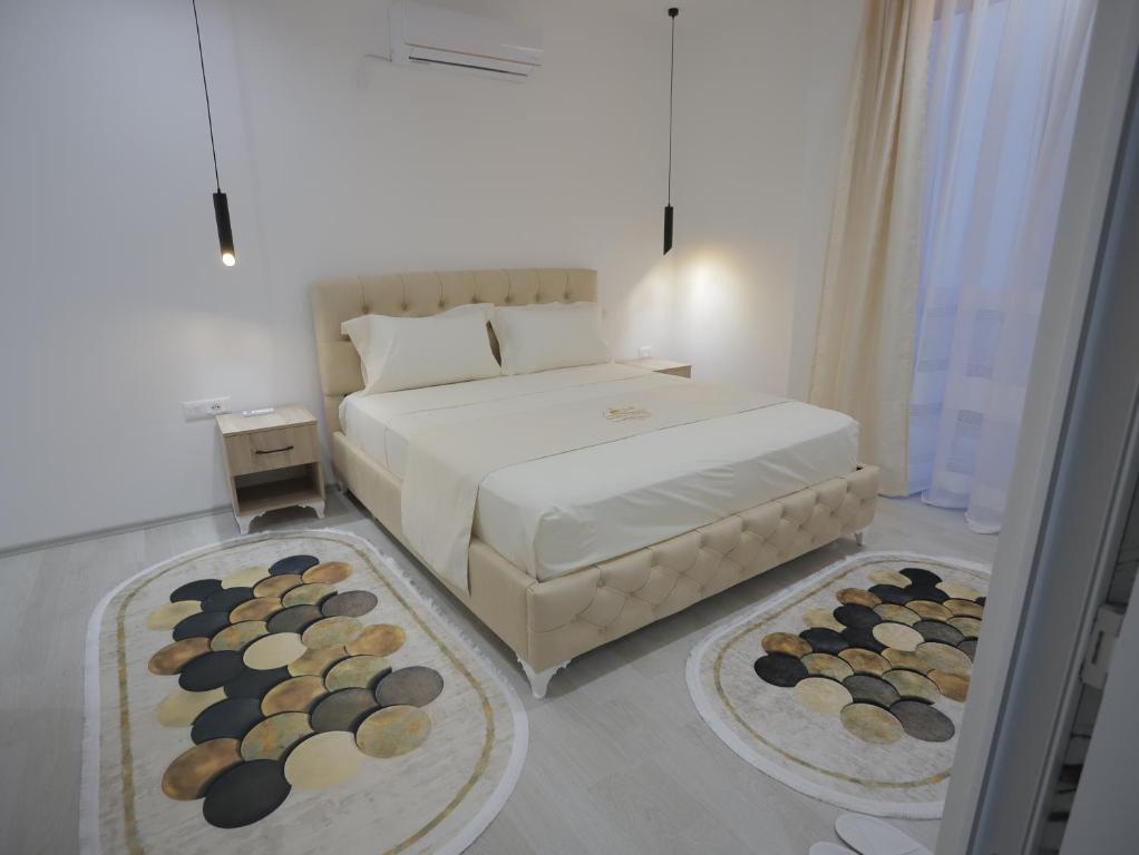 a bedroom with a bed with two rugs on the floor at Shatri Hotel in Vranisht
