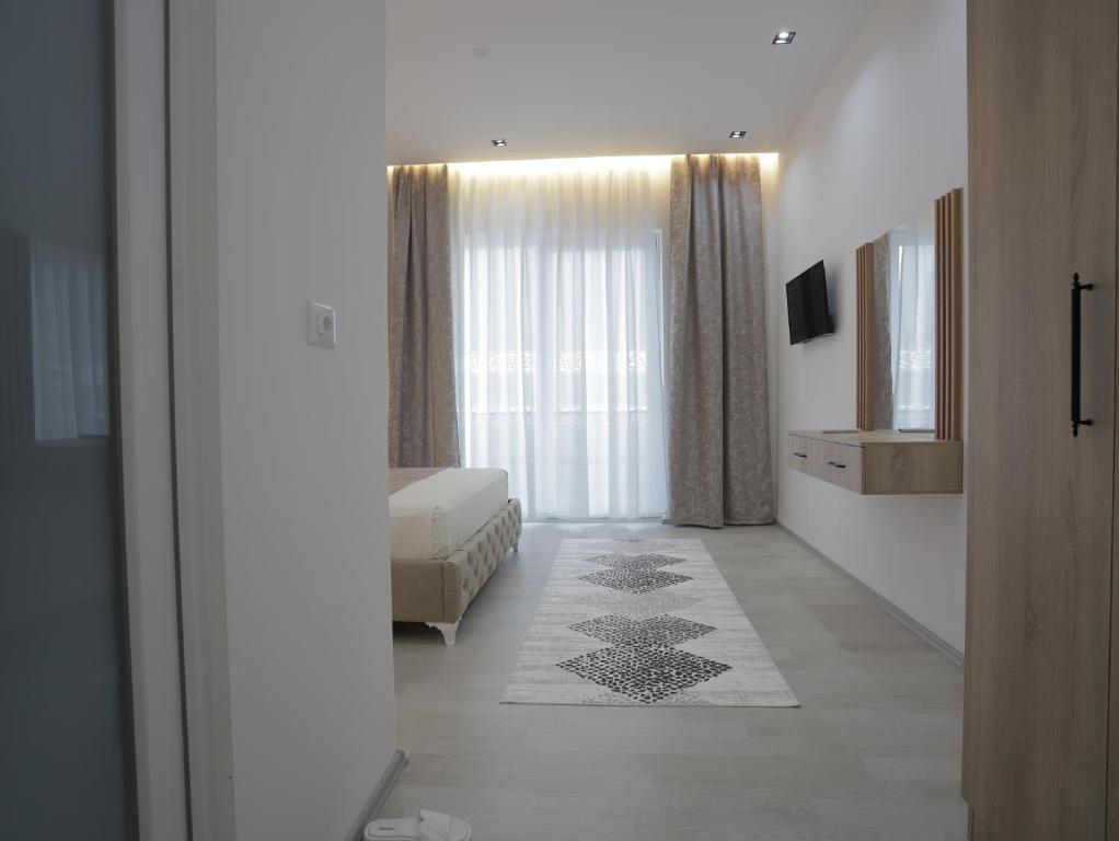 a bedroom with a bed and a large window at Shatri Hotel in Vranisht