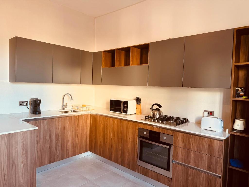 una cucina con mobili in legno e un forno a piano cottura di Sliema Shoreside Suite a Sliema